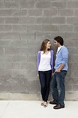 Young Couple Standing in front of Stone Wall