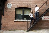 Portrait of Young Couple Standing on Fire Escape in Alleyway, Toronto, Ontario, Canada