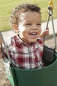Close-up Portrait of Young Boy in Swing at Playground
