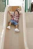 Young Boy Sliding Down Slide at Playground
