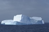 Sunlit iceberg in the dark blue waters of the Antarctic Sound at the Antarctic Peninsula, Antarctica