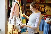 Pregnant woman looking at kids' clothes