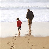 A 5 years old boy and his dad on the beach