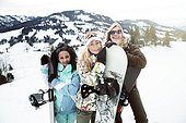 portrait of 3 young women in the snow, on winter holiday, snowboarders