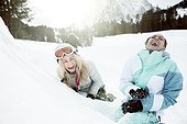portrait of 2 young women laughing in the snow, on winter holiday