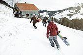 Young people returning to the house after a day on snowboards, winter holiday at original old swizz Charlet/ cabin,