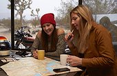 Two young women planning a motorcycle road trip