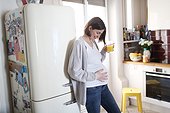 A pregnant woman drinking orange juice at home