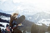 portrait of young woman with snowboard, in the snow, on winter holiday