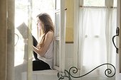 Young Latina woman relaxes on windowsill, reading