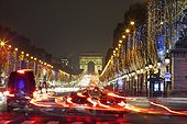 Traffic along the 'Champs Elysees' with Christmas lights looking toward the iconic 'Arc de Triomph' illuminated at night
