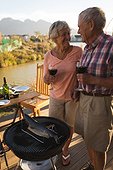 Happy senior couple having wine in the backyard