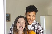 Portrait of happy diverse couple embracing at home, copy space