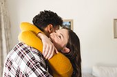 Happy diverse couple embracing at home, copy space