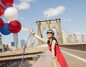 Woman with bunch of balloons on urban bridge