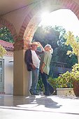 Senior couple talking in sunny summer villa archway