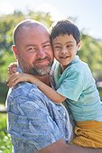 Portrait smiling father holding cute son with Down Syndrome
