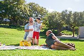 Happy family relaxing and playing with bubbles in sunny summer park
