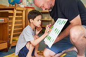 Father and son with Down Syndrome learning about plants at home