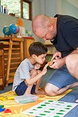 Father teaching son with Down Syndrome about plants at home