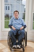 Man with spinal cord injury in a wheelchair smiling in his accessible home