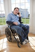 Man with spinal cord injury in a wheelchair talking on a mobile phone