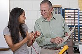 Engineering professor showing a resistor value chart to a student