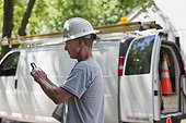 Cable installer reviewing work order for installation on smartphone