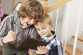 Close-up of two brothers playing on a digital tablet