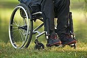 Low section view of a man in wheelchair with spinal cord injury in a park