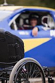 Wheelchair in front of stock car modified for disability racing