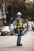 Cable installer carrying video cables on a street