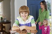 Boy at home with mother and sister entering the room