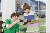 Two boys using a digital tablet and a smart phone