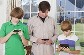 Man and his two son using smart phones and digital tablet