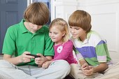Girl and her two brothers using a smart phone