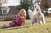 Girl playing ball with pet Terrier