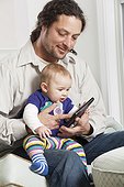 Father and baby looking at electronic tablet at home