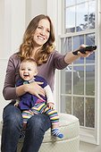 Woman watching TV with smiling baby
