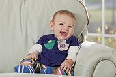 Close-up of a laughing baby on couch