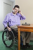 Man in wheelchair with spinal cord injury using his cell phone