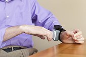Man with spinal cord injury checking his blood pressure gauge on his wrist