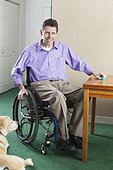 Quadriplegic man in wheelchair with spinal cord injury opening pill case