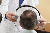 Audiologist placing a headset on a patient for audiometric evaluation