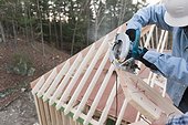 Carpenter using a circular saw to recut rafter bevel