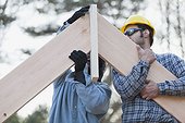 Carpenters placing rafters at peak