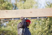 Carpenter measuring horizontal roof joist