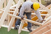 Carpenter placing a rafter for dormer