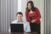 Hispanic businesswoman and businessman looking at computer