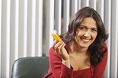 Businesswoman holding pill bottle and smiling